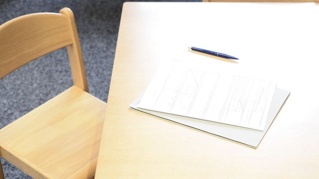 student desk with pen and paper